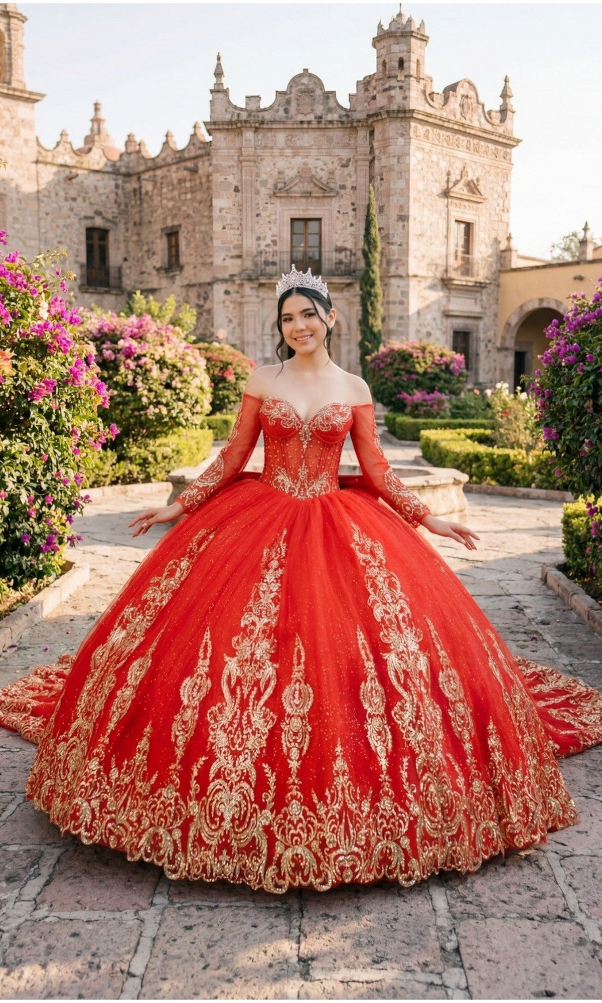 A young woman wears the Quinceanera Dress 8545JQ By Cinderella Couture in red, featuring beaded sequin details, as she stands on a stone path before a historic building amid blooming gardens.
